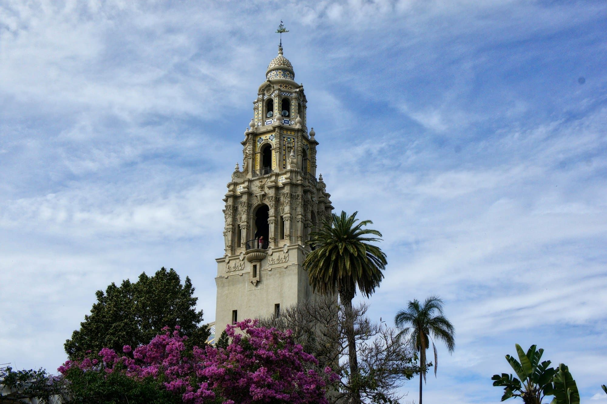 A large clock tower with a cross on top of it