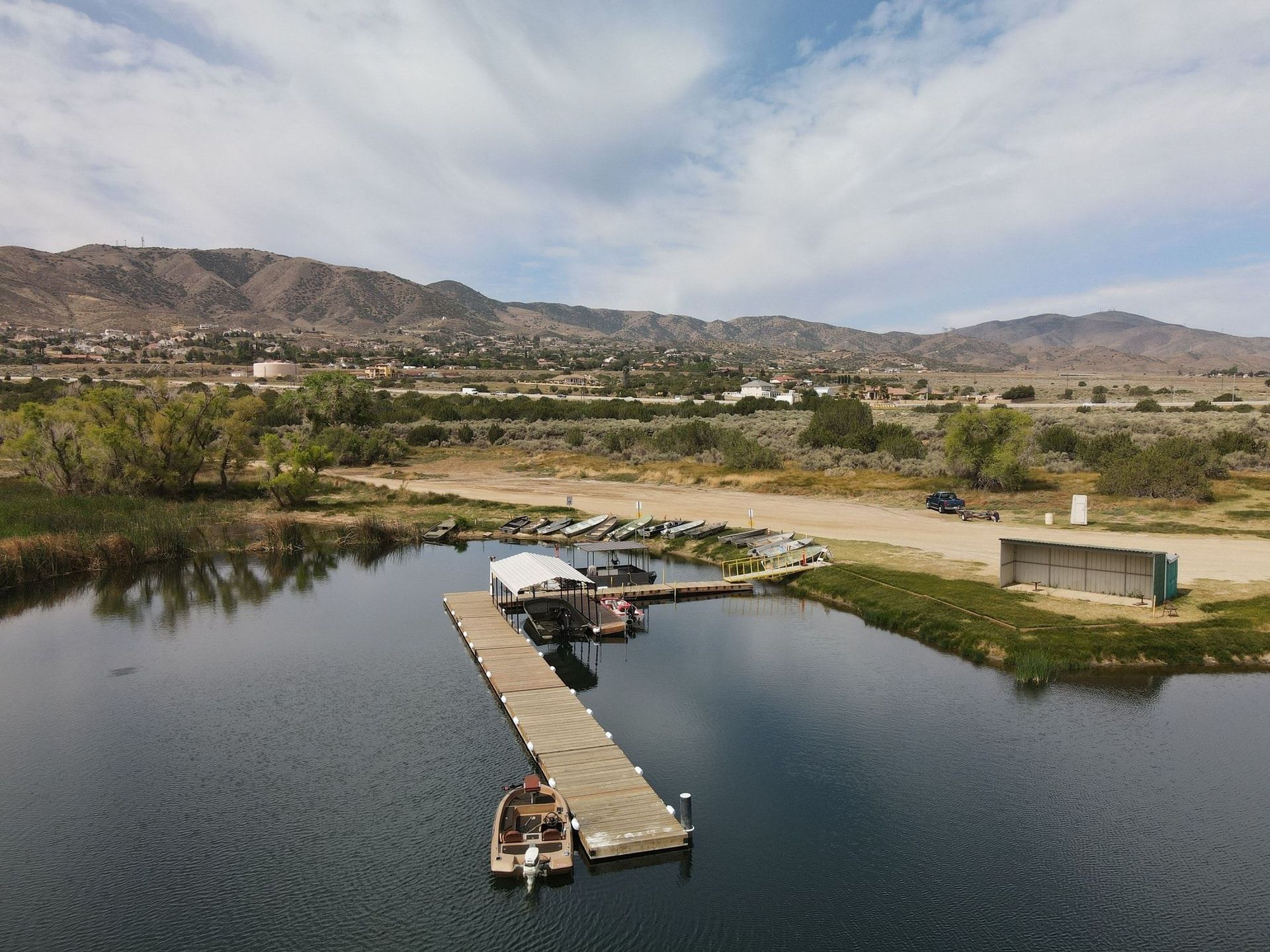 An aerial view of a dock on a lake with mountains in the background