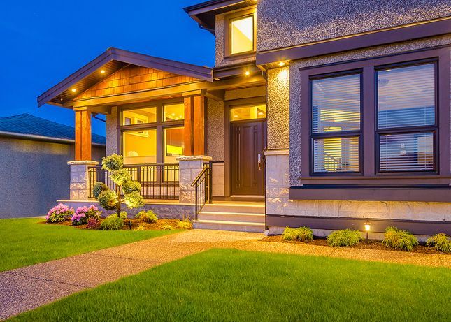 A large house with a lot of windows is lit up at night.