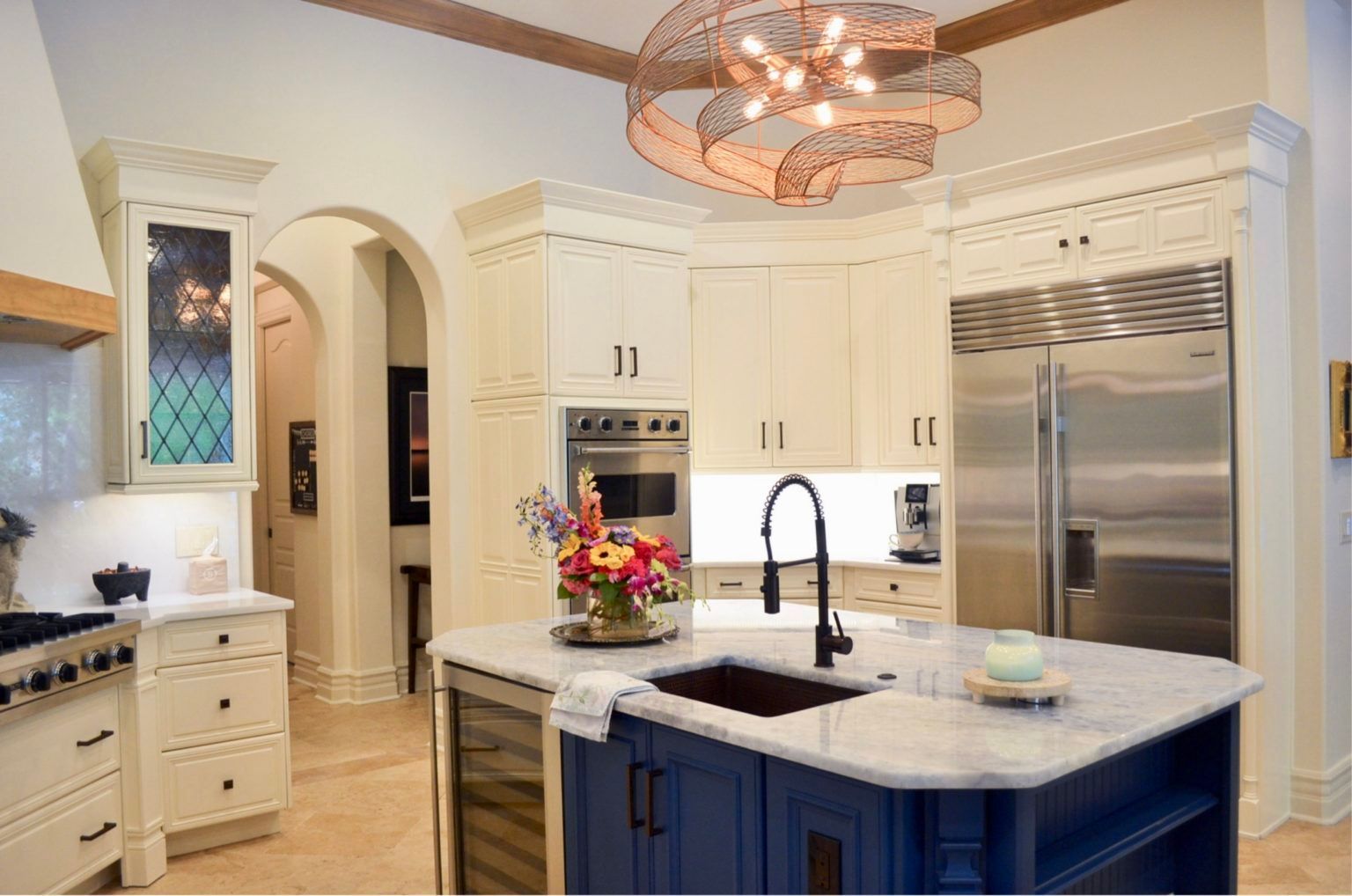 A kitchen with blue cabinets , white cabinets , stainless steel appliances and a large island.