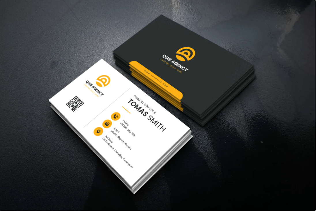 Dos pilas de tarjetas de presentación, una blanca y otra negra, con detalles dorados, sobre una superficie oscura.