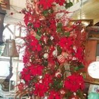 Red floral arrangement with branches and ornaments in a decorated indoor room