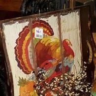 Abstract painting of a colorful rooster with red, orange, and yellow feathers on a canvas