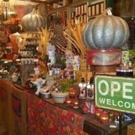 Decorative market stall with pumpkins, jars, and an “OPEN” sign in a rustic shop display