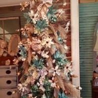 Decorated Christmas tree with gold and turquoise ornaments in a room