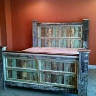 Two rustic wooden headboards against a red wall, one wide in front and one taller behind.