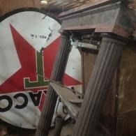 Broken columns and a damaged red-and-white ACC sign amid debris inside a collapsed structure