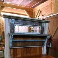 Old wooden mantel or cabinet with mirror shelves inside a barn interior
