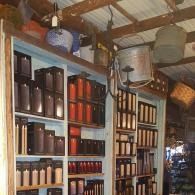 Shelves of assorted jars and bottles in a rustic shop with a wooden ceiling