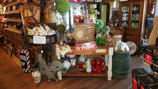 Vintage shop display with Dr Pepper crate, pumpkins, and rustic decor on a wooden porch