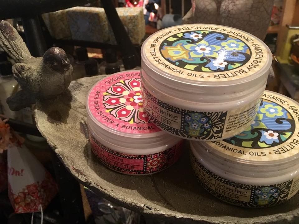 Stacked colorful cosmetic jars on a shelf beside a small black bird figurine