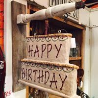 Rustic hanging sign with “HAPPY BIRTHDAY” in black letters on two wood planks