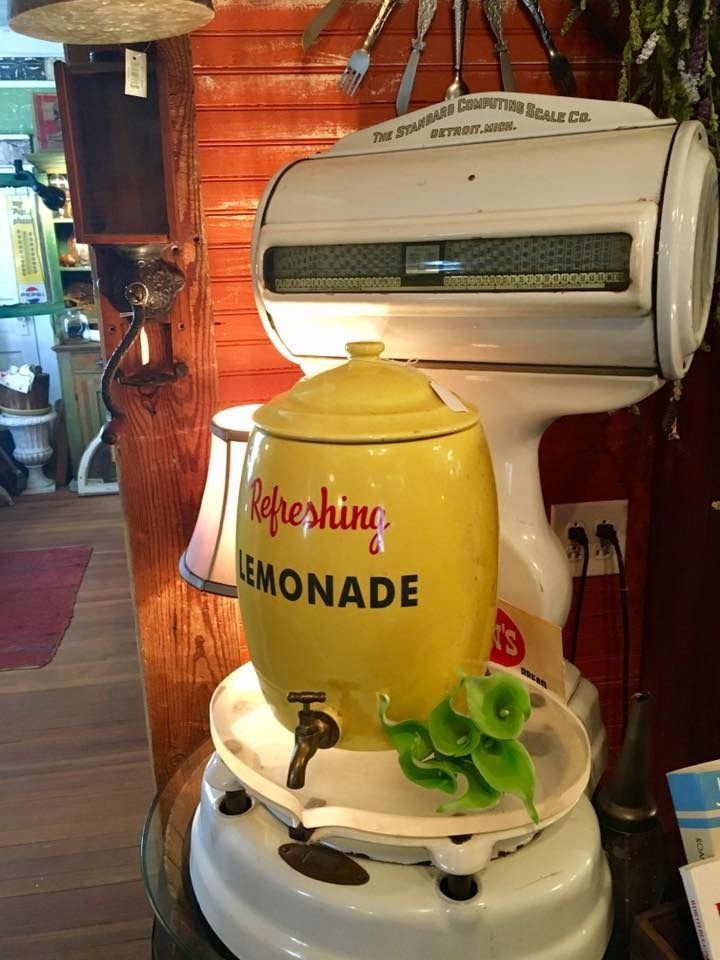 Yellow “Refreshing Lemonade” drink dispenser in a rustic café setting