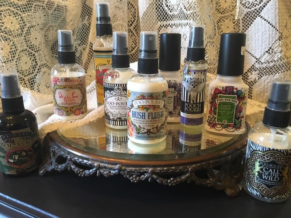 Assorted small perfume bottles on an ornate tray against patterned lace curtains.
