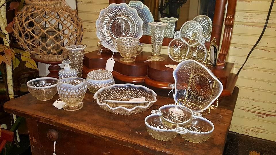 Clear glass and crystal dishes displayed on a wooden table in a warm-lit room