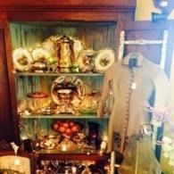 Decorative shelf with bowls, fruit, and hanging clothing in a warmly lit room