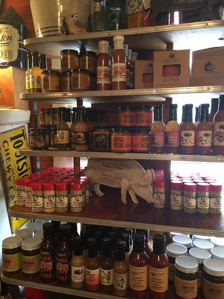 Wooden shelves stocked with assorted sauces, condiments, jars, and bottles in a pantry or store display