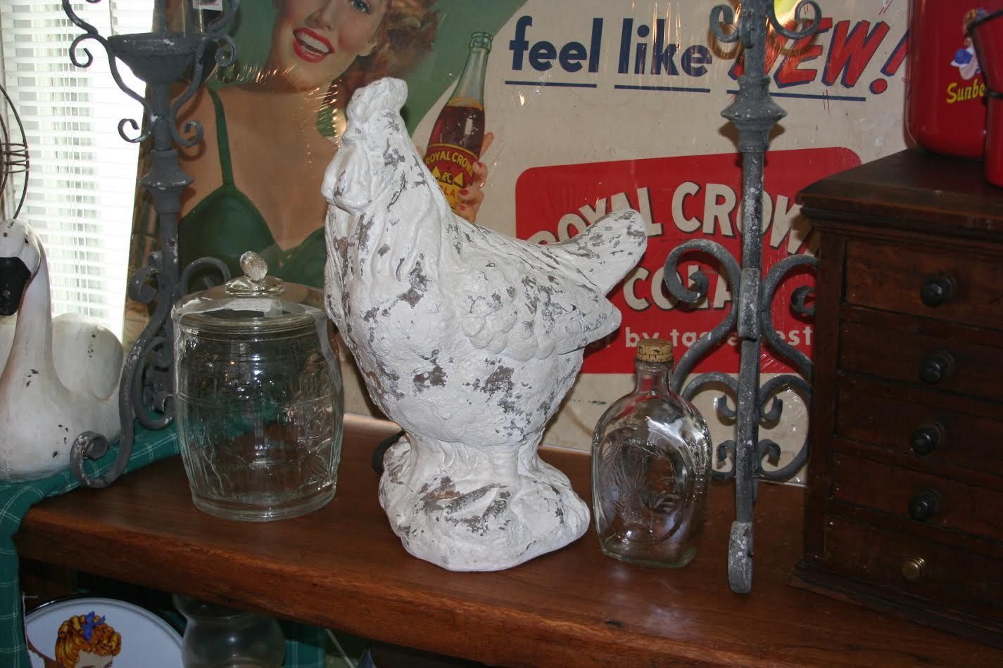 Rustic wooden shelf with a white rooster statue, glass jars, and vintage decor items