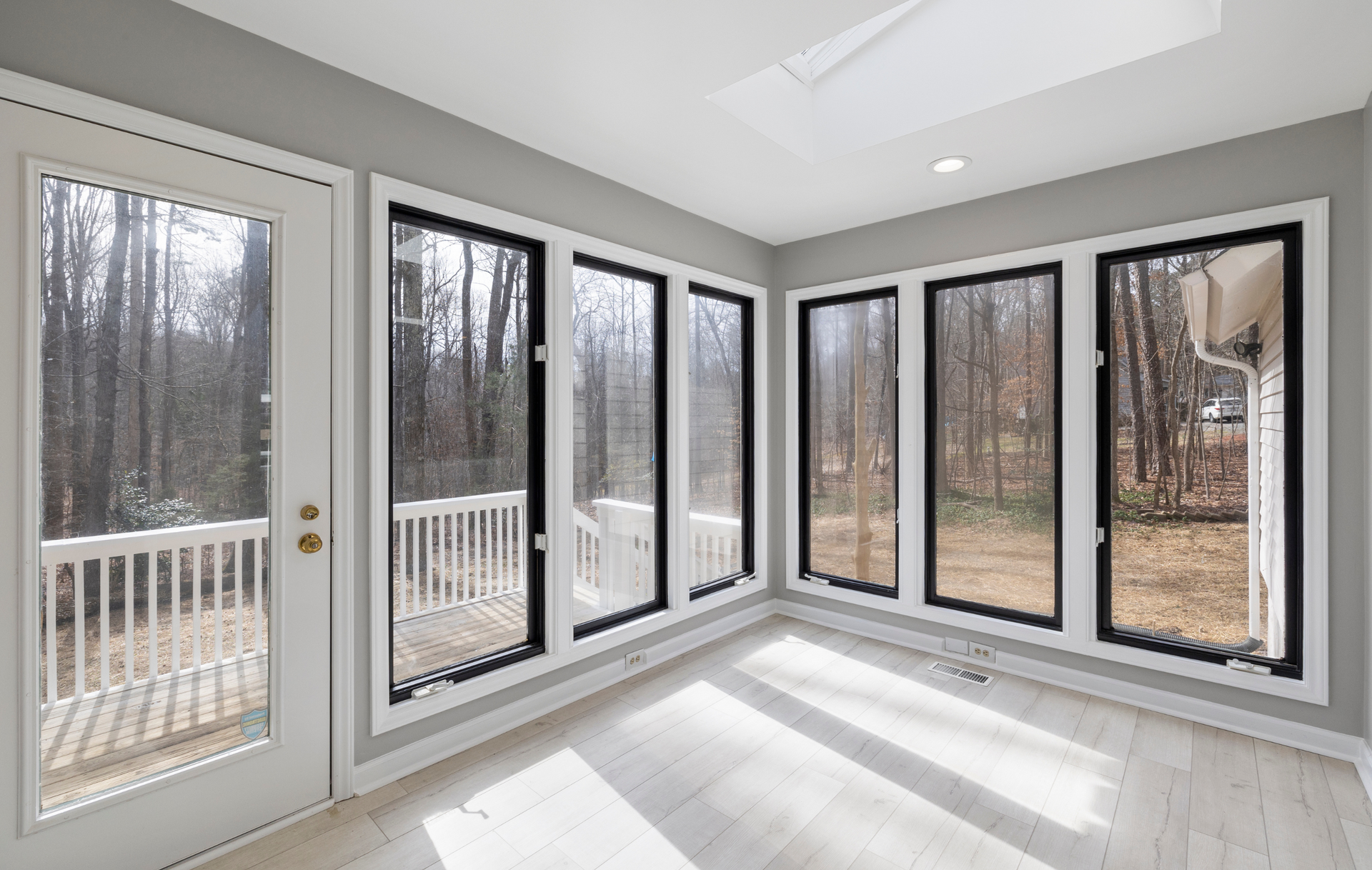 An empty room with a lot of windows and a balcony.
