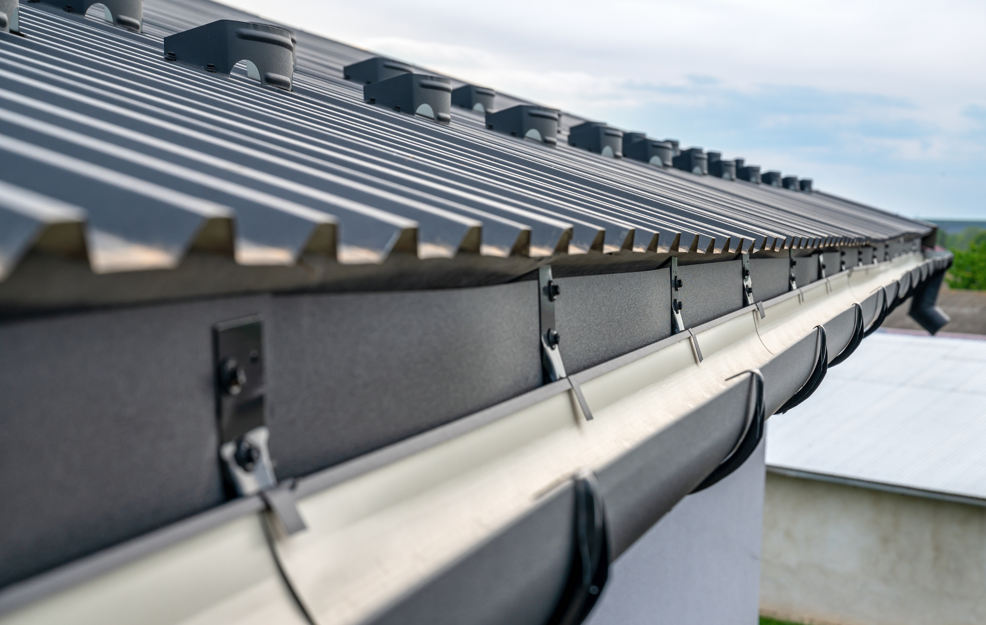 A close up of a gutter on a roof of a house.
