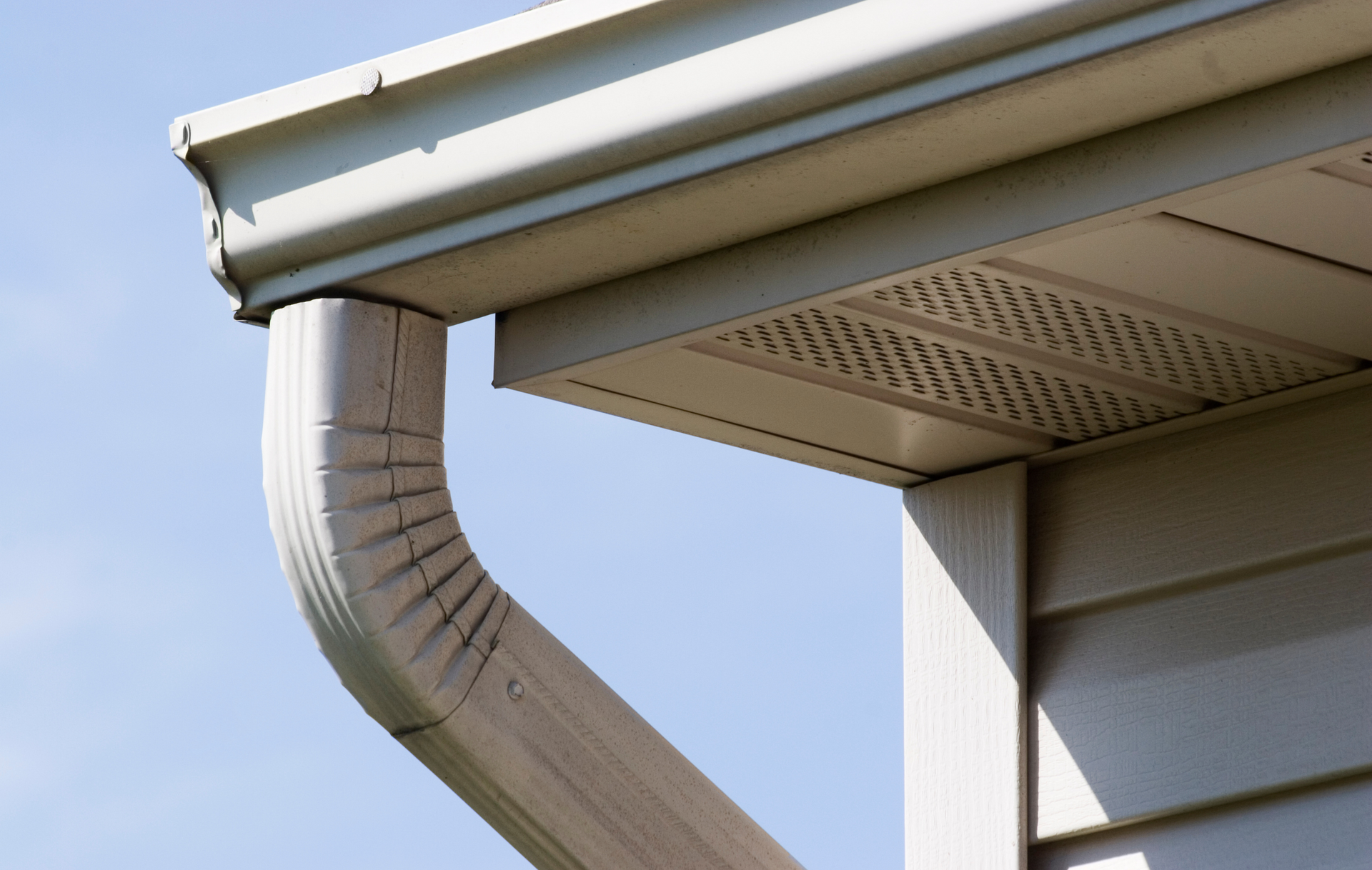 A close up of a gutter on the side of a house.