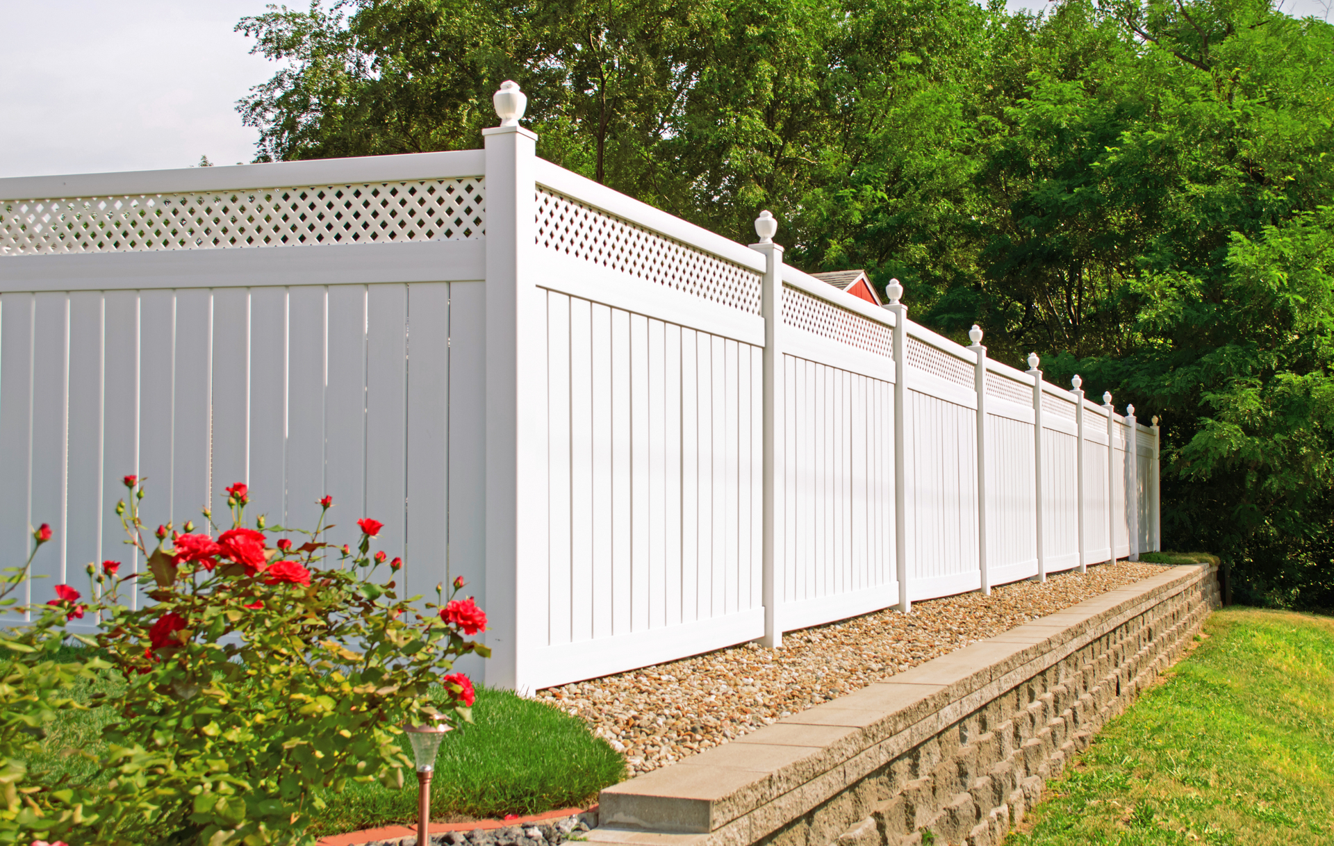 A white fence with flowers in front of it