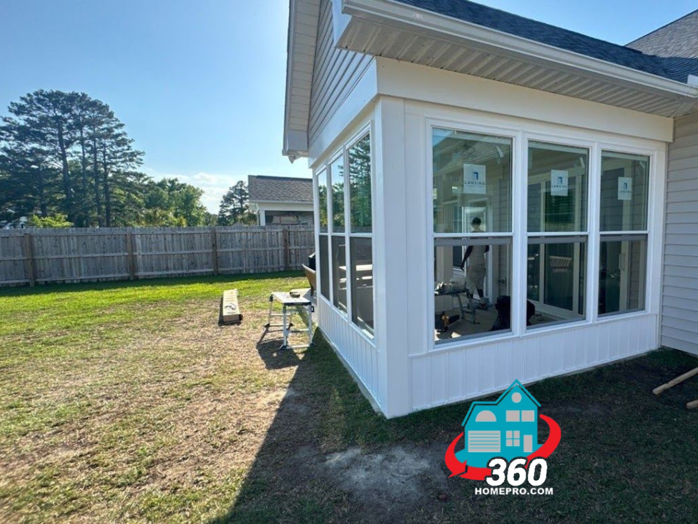 A house with a screened in porch and a lot of windows.