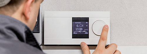 Technician adjusting thermostat—heater in Brookville, OH Technician adjusting thermostat—heater in Brookville, OH