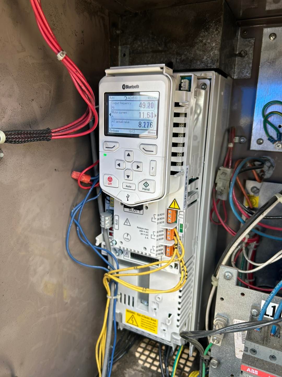 Variable frequency drive in an enclosure with wiring and control panel display.