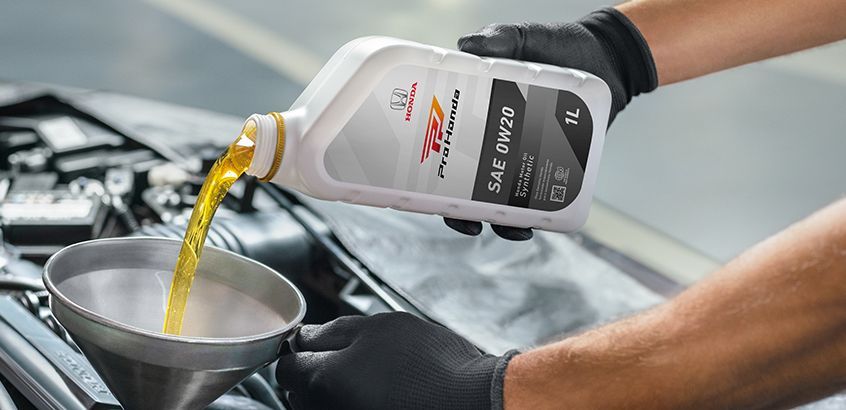 Colaborador utilizando óleo de motor original Honda na oficina Honda Kaizen RS em Porto Alegre