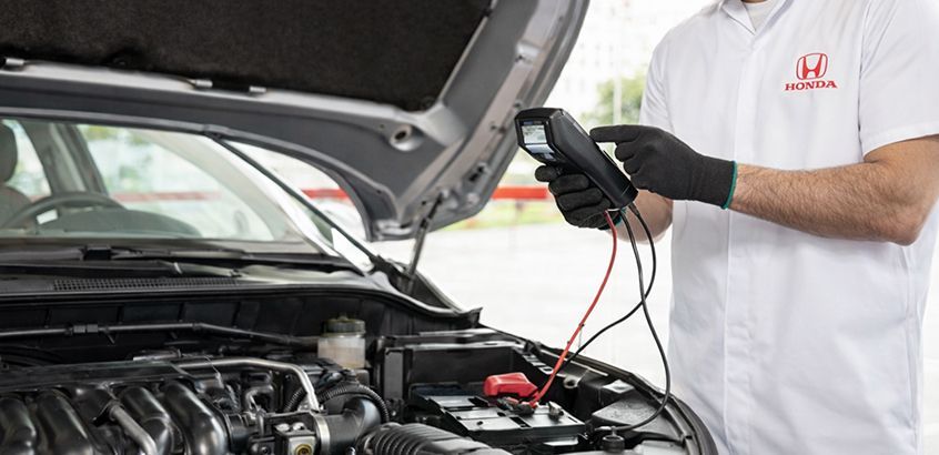 Colaborador realizando teste de bateria na oficina Honda Kaizen RS em Porto Alegre