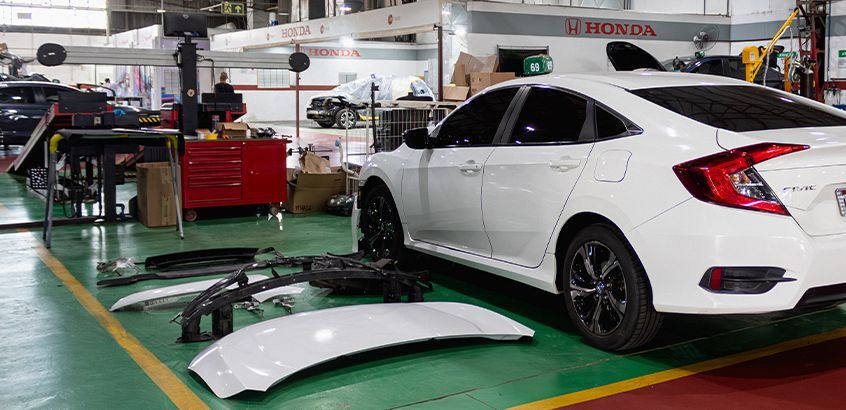 Honda Civic branco recebendo manutenção na oficina de Funilaria e Pintura da Honda Kaizen RS em Porto Alegre.
