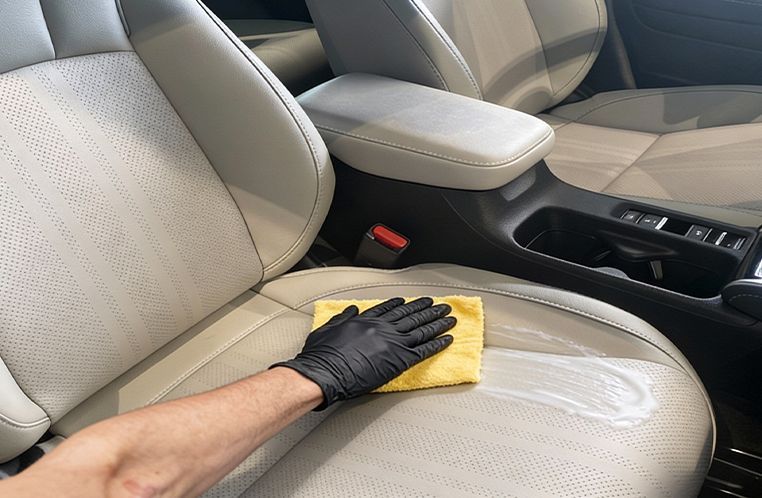 Mão hidratando o banco de couro de um Honda 0km