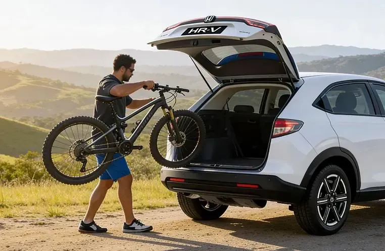 Homem colocando uma mountain bike no porta-malas de um Honda HR-V branco