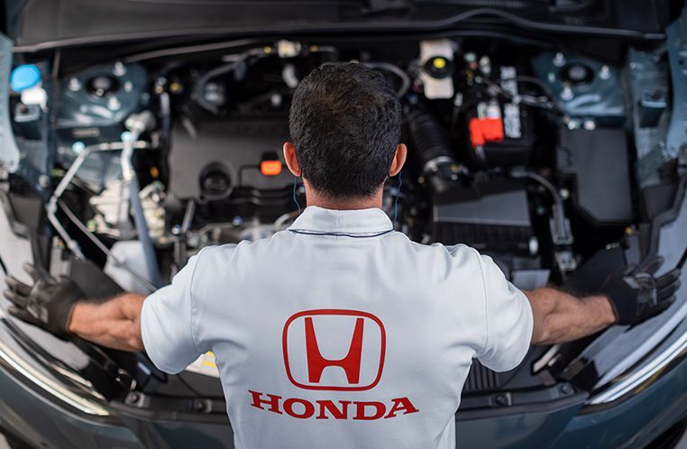 Colaborador Honda Kaizen RS realizando manutenção preventiva em um carro