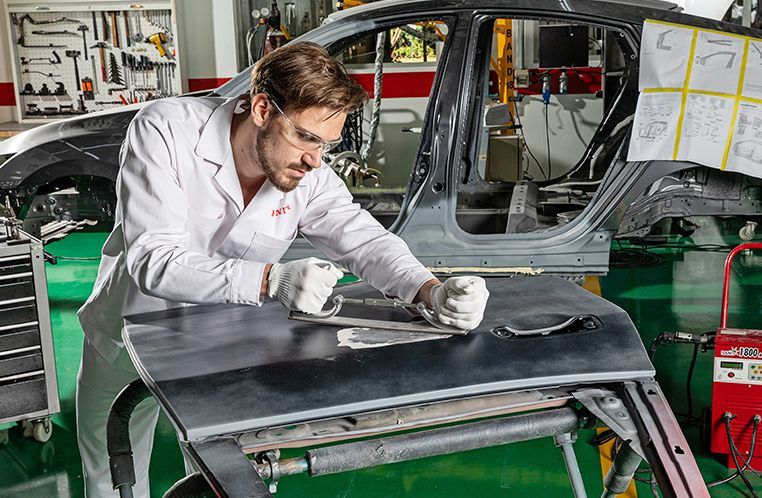 Colaborador Honda Kaizen RS realizando manutenção na funilaria de um Carro