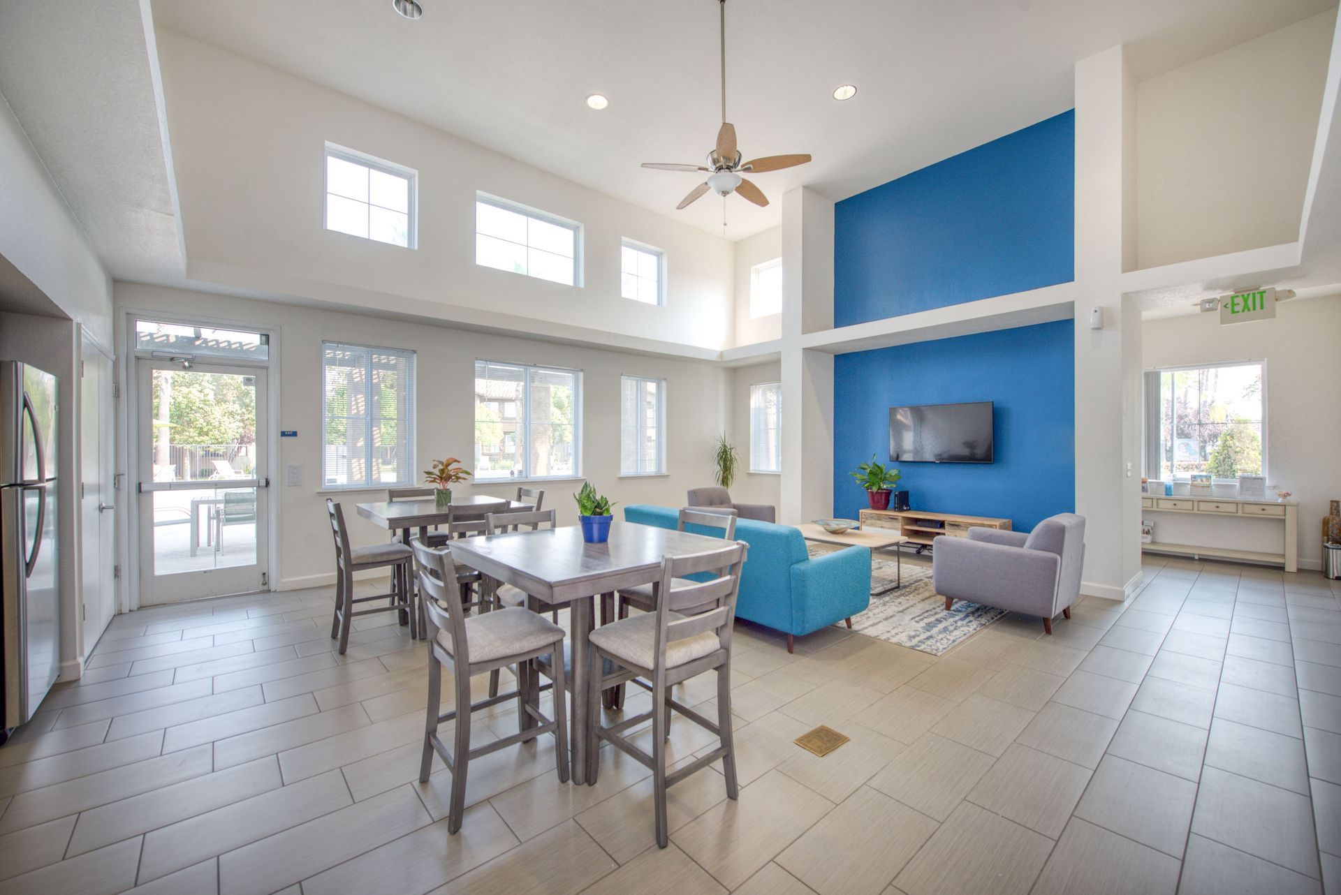 a large swimming pool is surrounded by chairs and umbrellas in front of a large building .