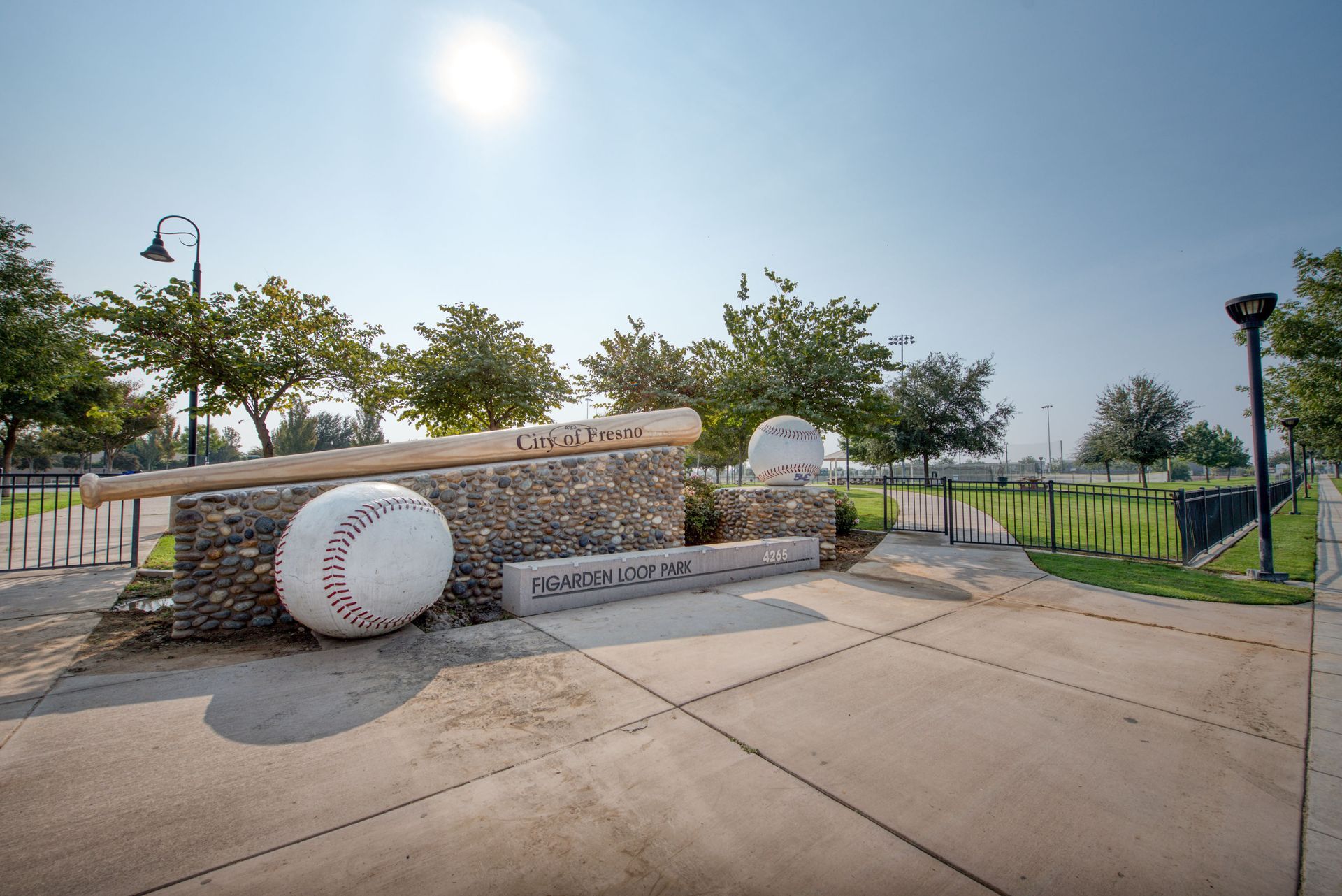 a large baseball and bat are sitting on top of a stone wall .