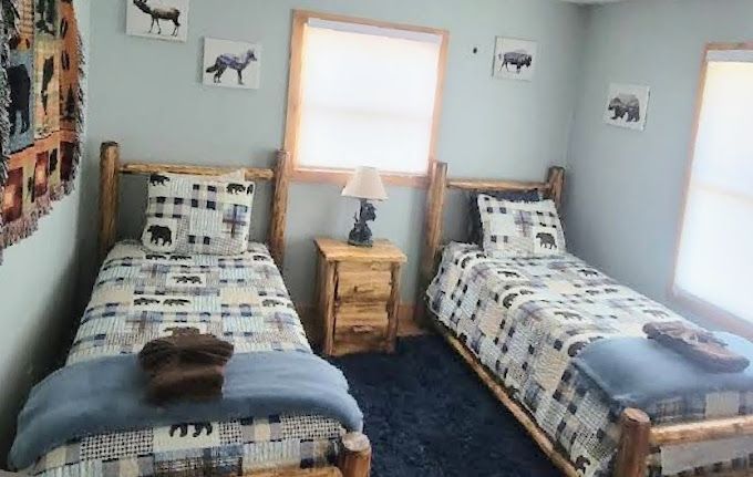 A bedroom with two twin beds and a nightstand.