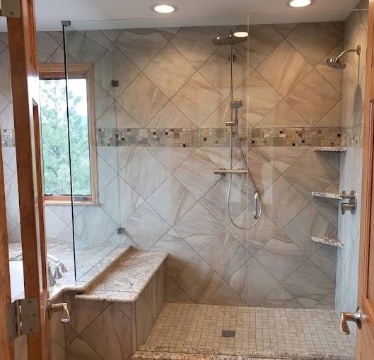 A bathroom with a walk in shower and a window.