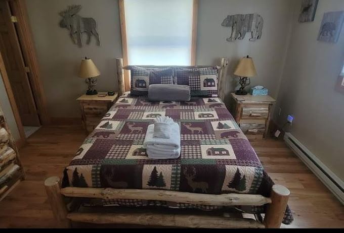 A bedroom with a bed , nightstands , lamps and a window.