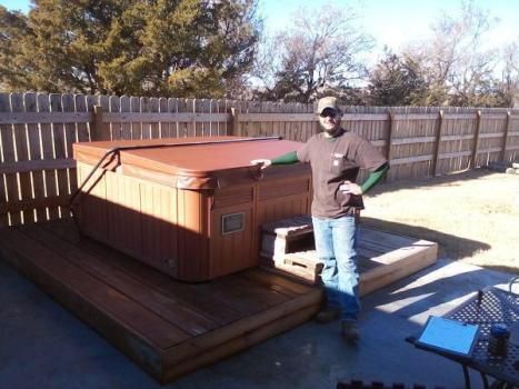 A man standing next to a hot tub in a backyard