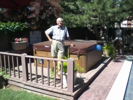 A man standing next to a hot tub on a deck