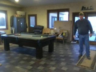 A man standing in a room with a pool table