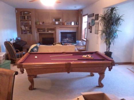 A pool table in a living room with a fireplace