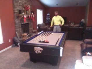 A man standing next to a pool table in a living room