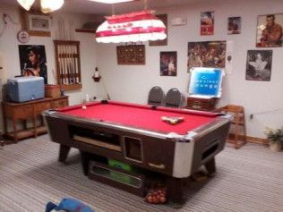 A pool table in a room with posters on the wall