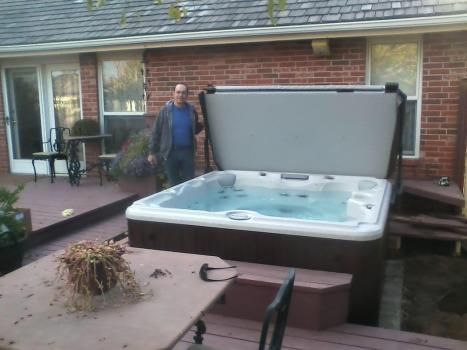 A man standing next to a hot tub on a deck