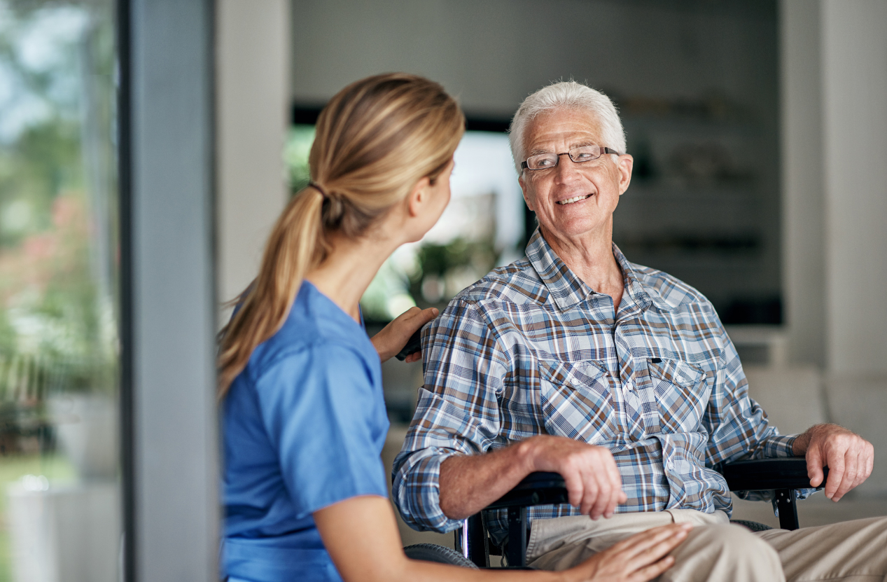 Caregiver smiling and engaging with a client at home