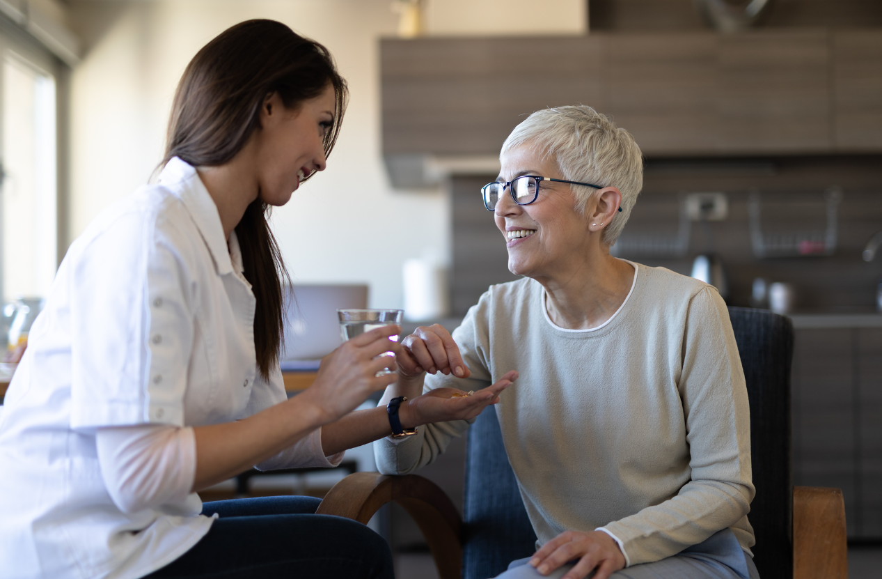 Caregiver assisting with meals and medication reminders for dementia care